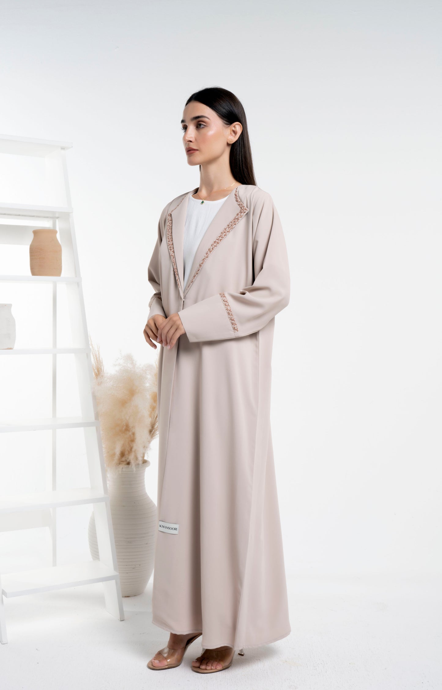 Girl wearing double collar abaya with floral embroidery detail on sleeves and collar.