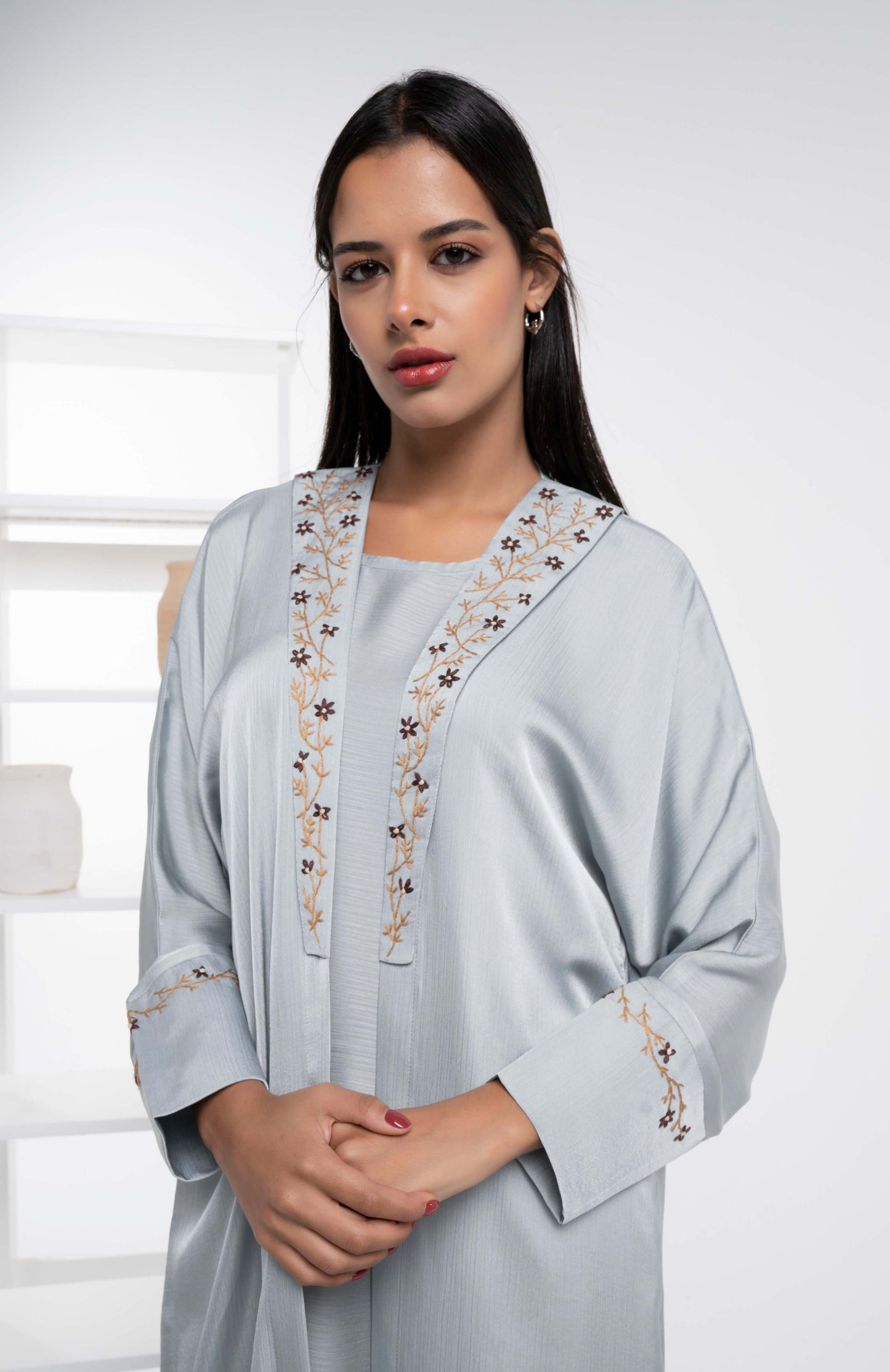 Girl wearing sea green abaya with floral embroidery on collar and cuff sleeves