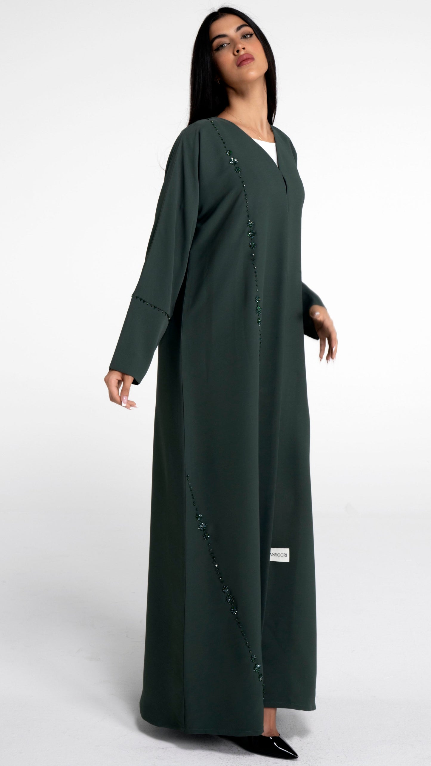 Girl wearing green abaya with flower motif design line on front