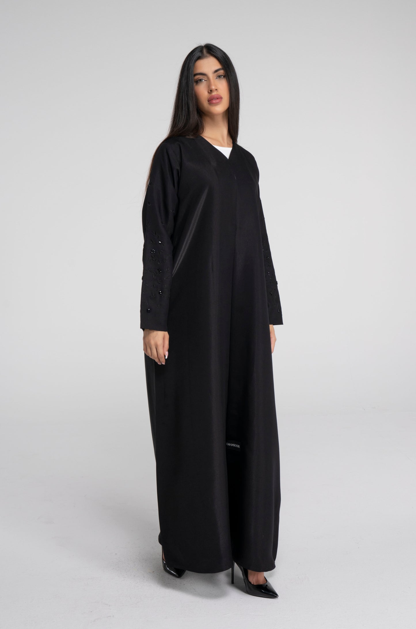 Girl wearing black abaya with floral embroidered sleeves