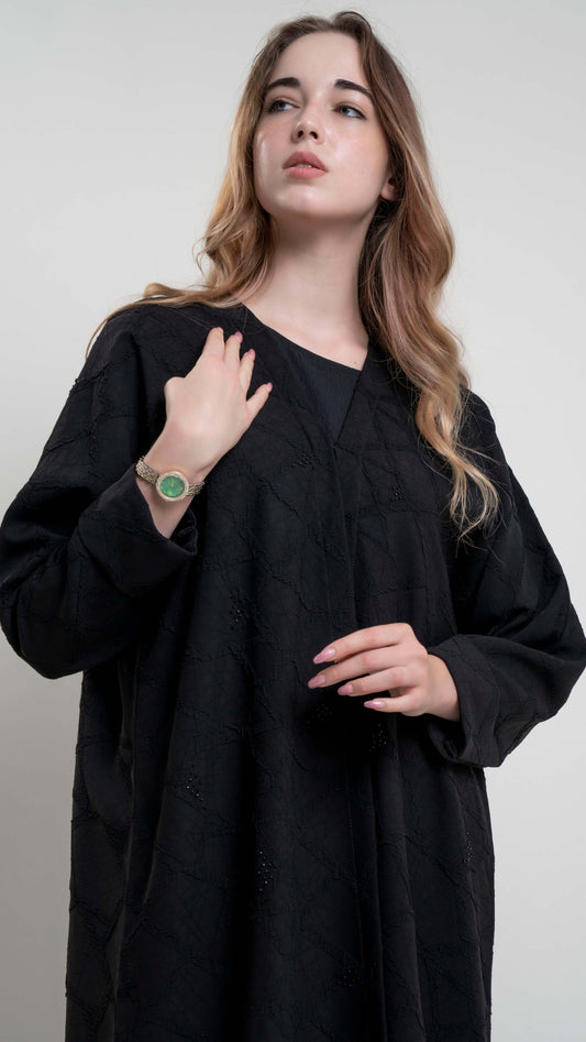 Half view of model wearing Bisht black Abaya with Simple Bead Highlights