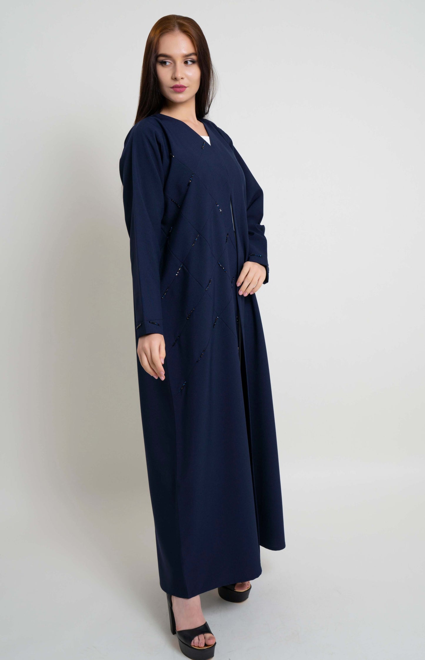 Side view of geometrical pintucks abaya with bead detailing.