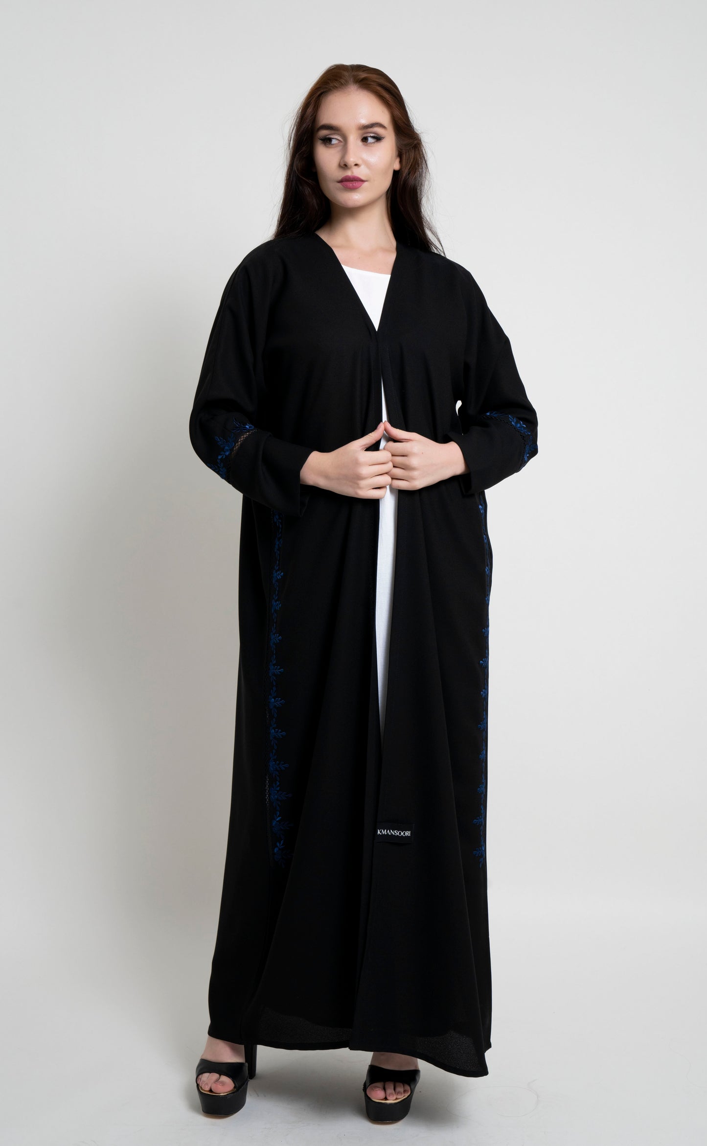 Girl wearing black abaya with floral design thread embroidery.