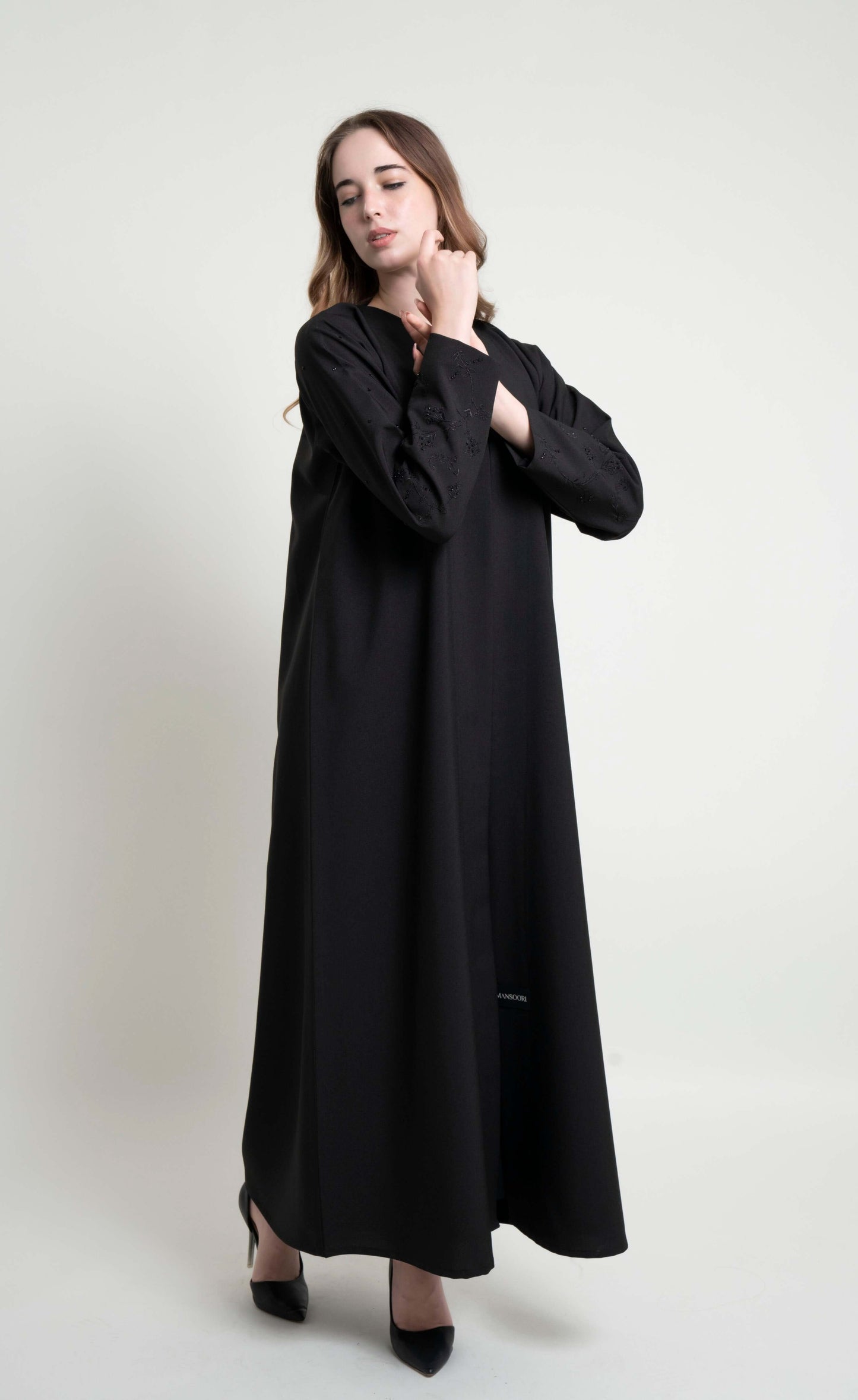Girl wearing black abaya with embroidered sleeves