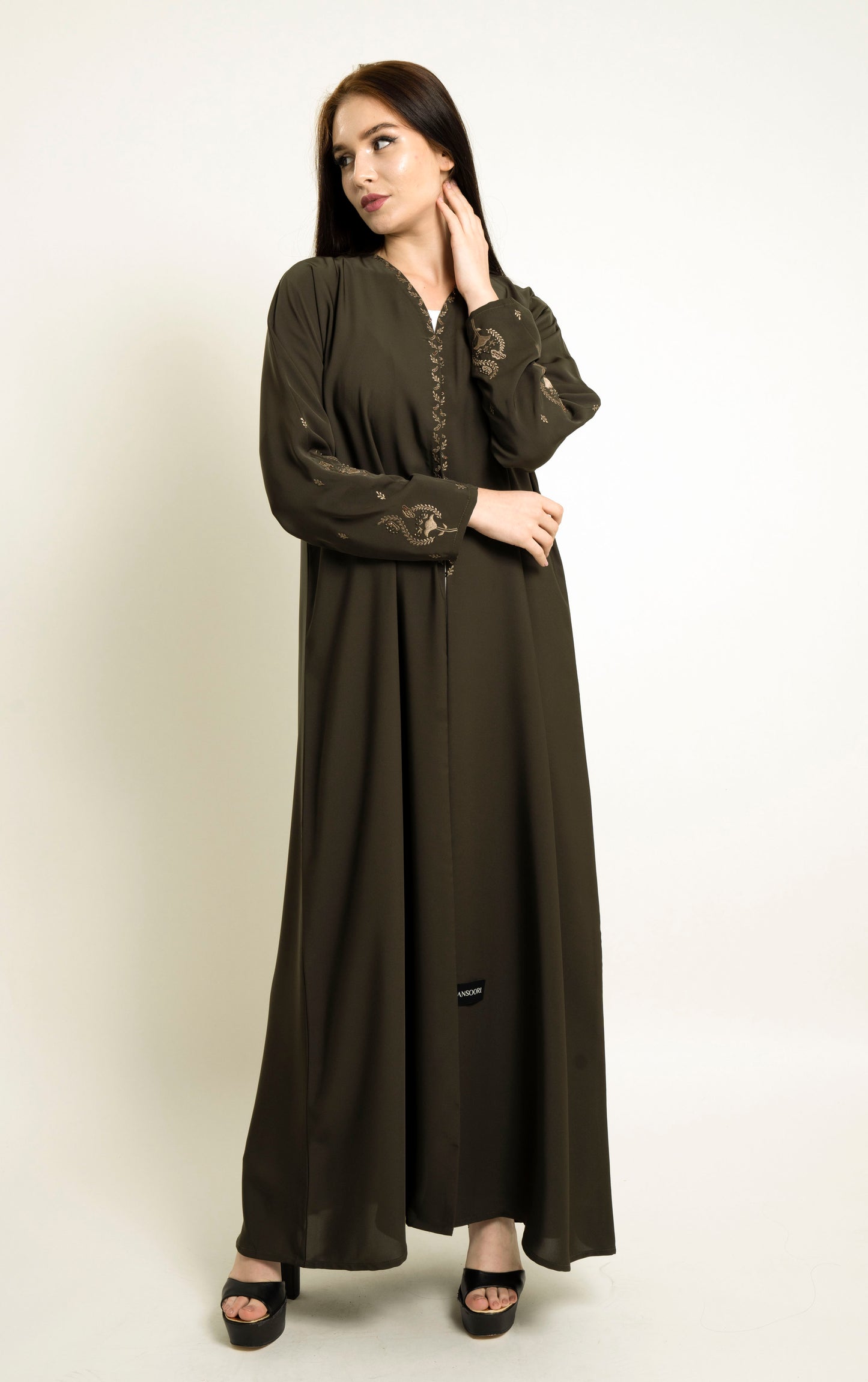Girl wearing green abaya with embroidered neckline and floral motif sleeves