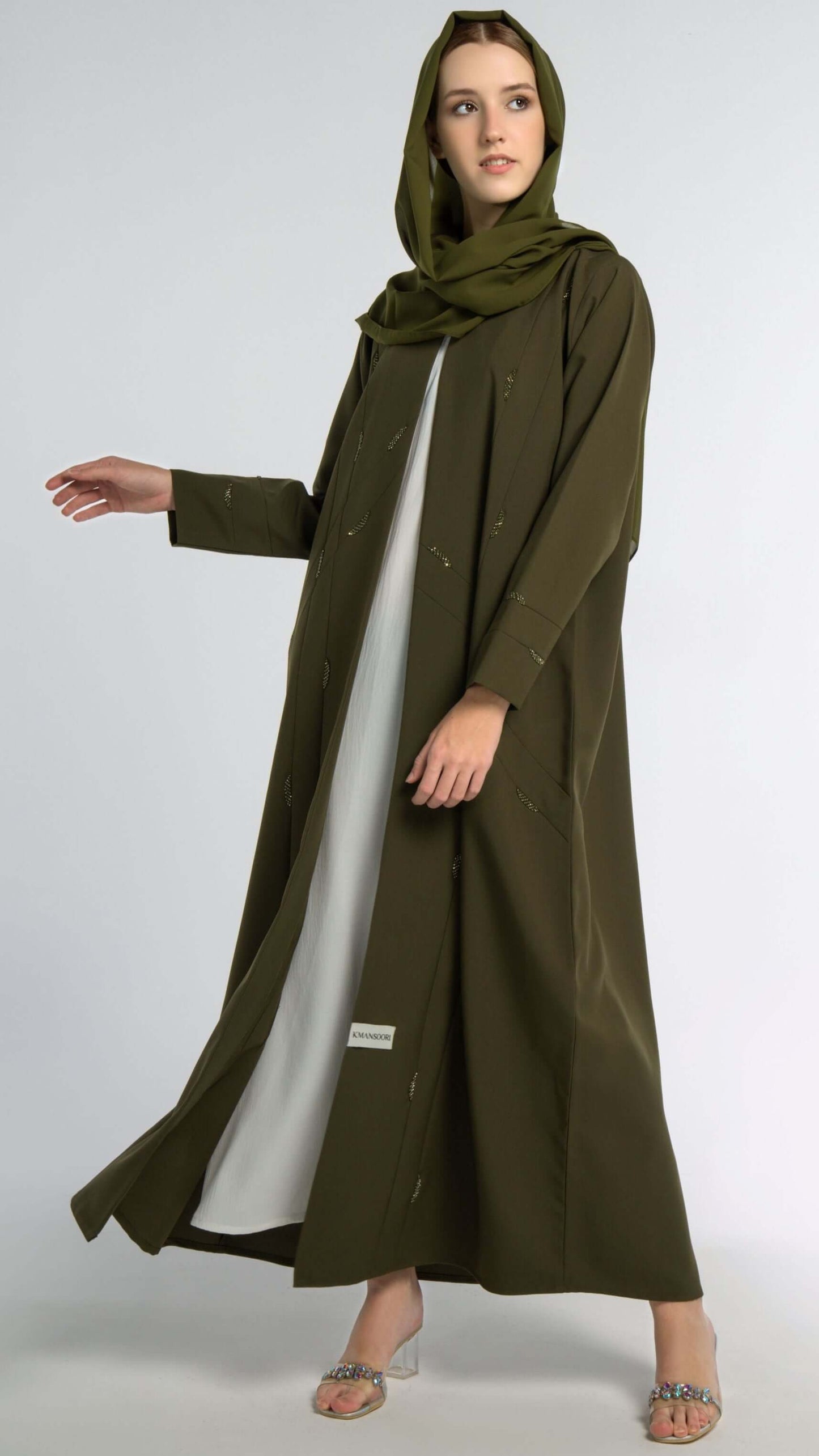Girl wearing green colored V-neck abaya with elegant line-patterned beaded embellishments.