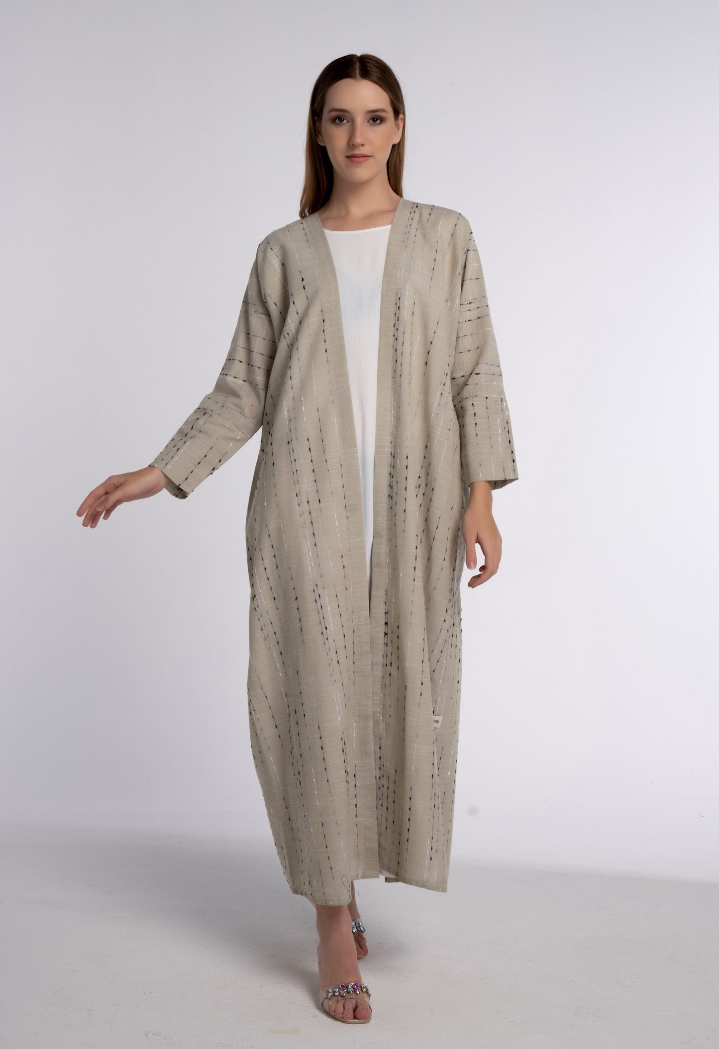 Girl wearing beige abaya with cut joined sleeve pattern.
