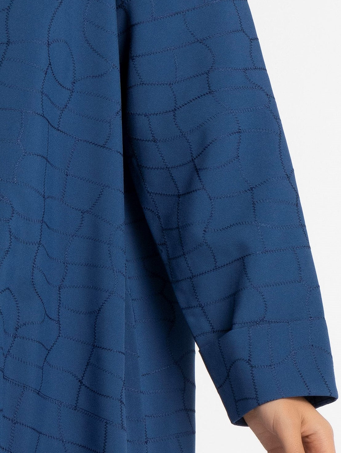 Detailed view of sky blue abaya with white pattern.