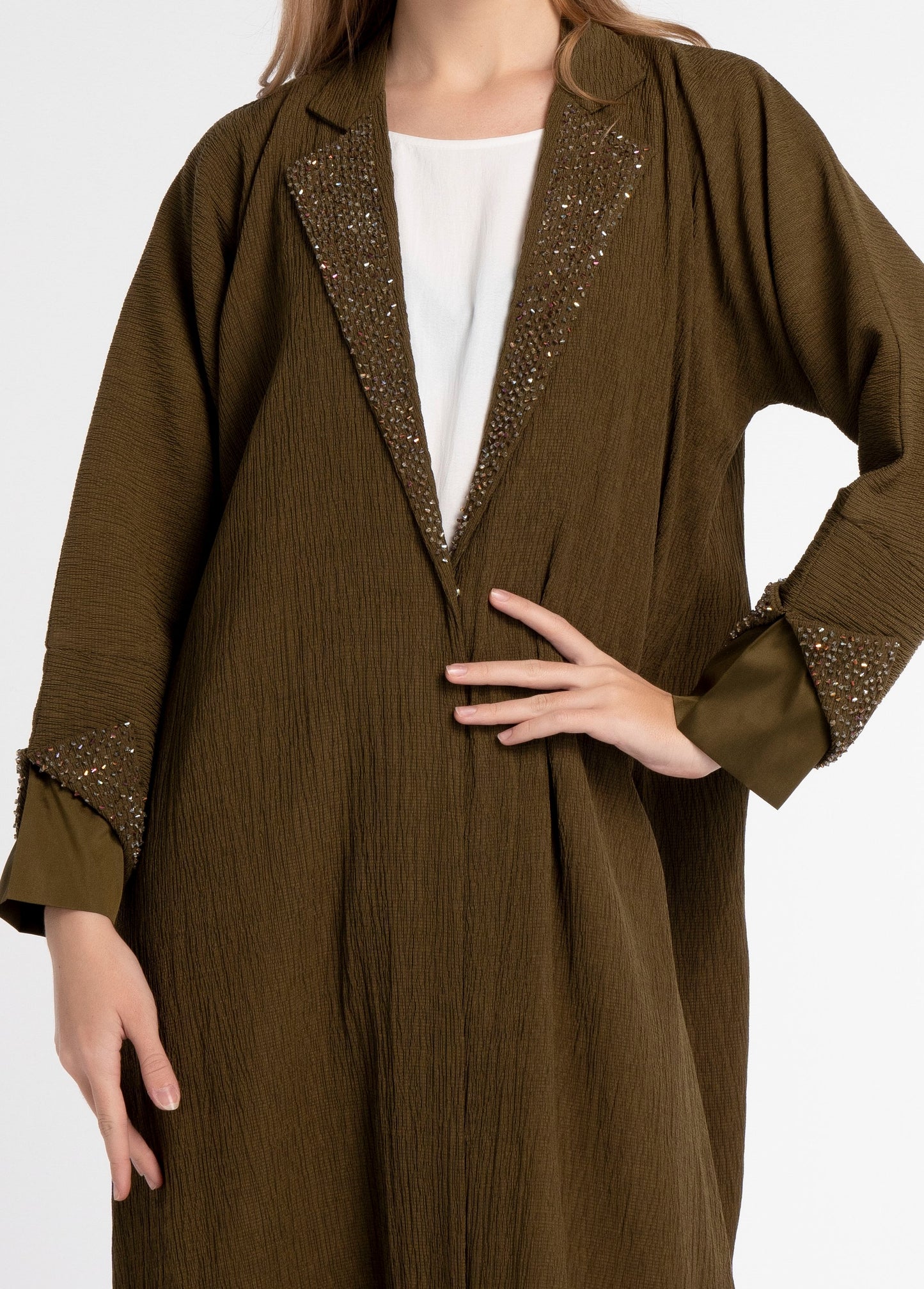 Detailed view of embellished design on green abaya