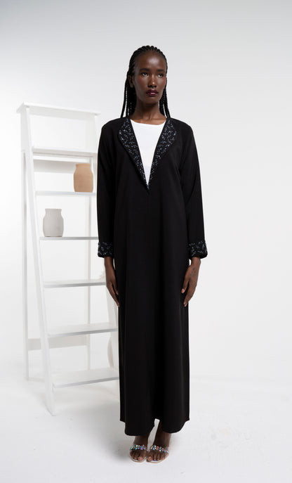 Girl wearing black color abaya with beadwork collar and folded cuff sleeves