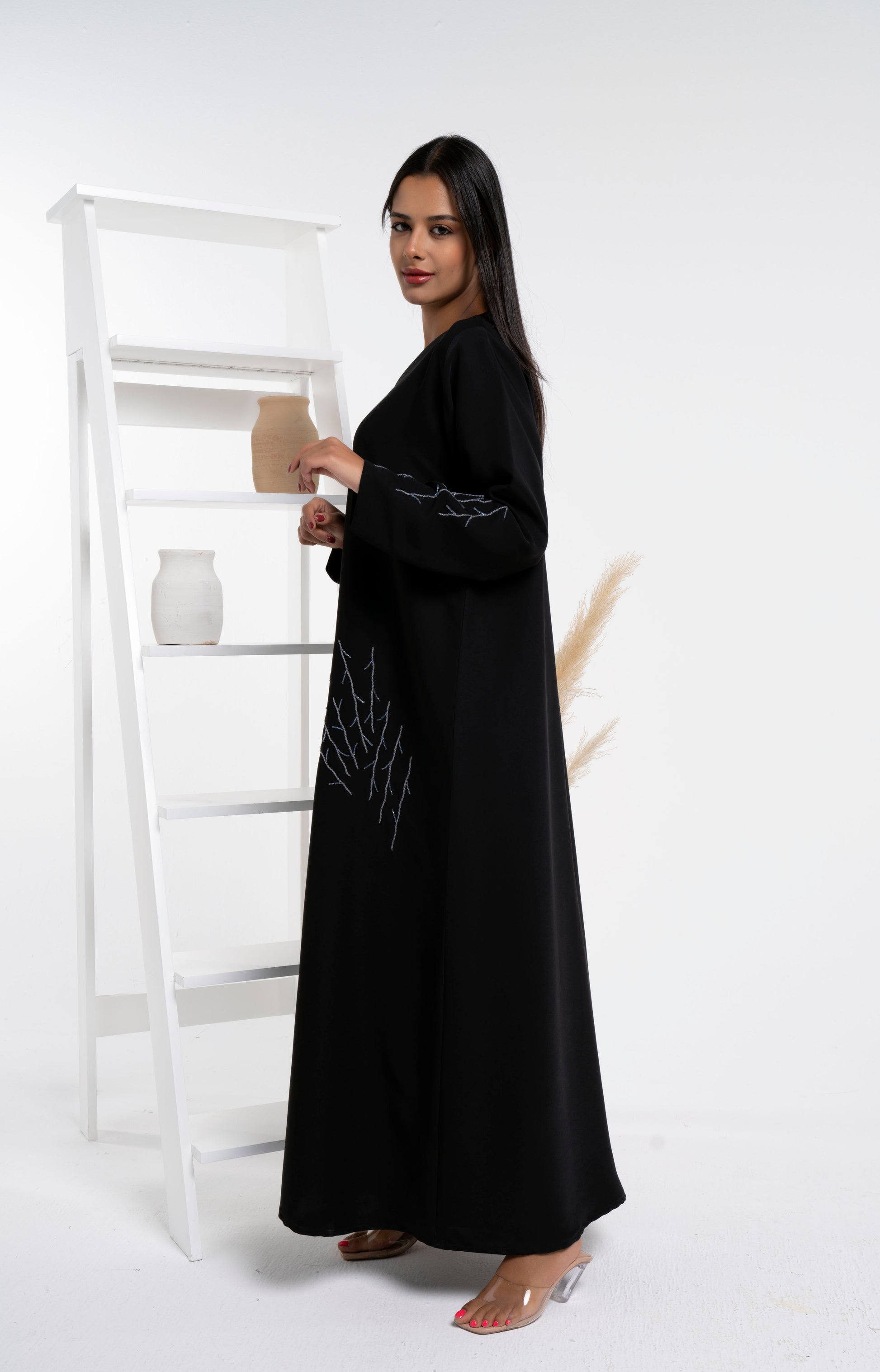 Side view of black abaya with bead detailing on front and sleeve