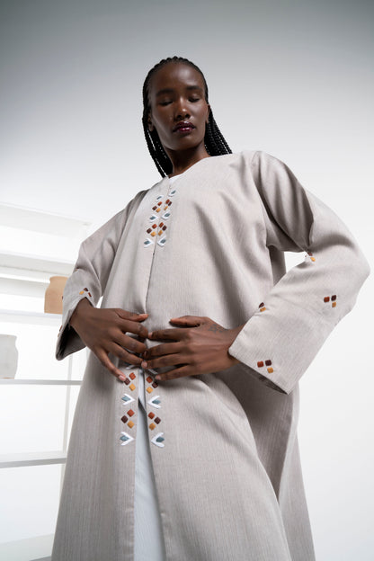 Detail view of thread embroidery on frontline and sleeves.