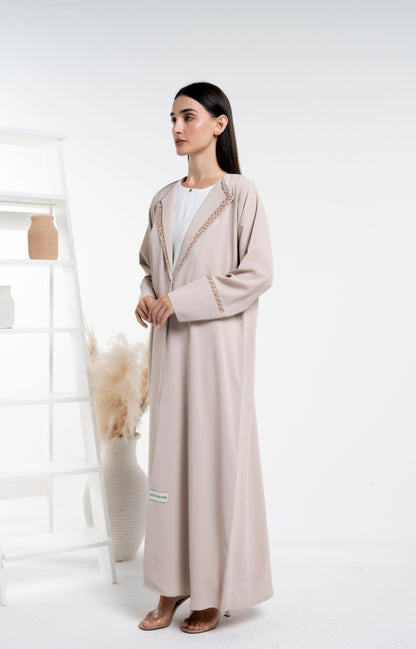 Girl wearing double collar abaya with floral embroidery  detail on sleeves and collar.
