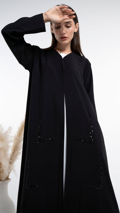 Girl wearing geometric design abaya with beads detailing