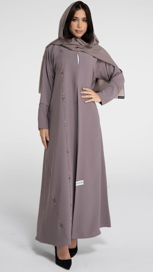 Girl wearing brown abaya with flower motif design line and simple bead line on sleeve. 