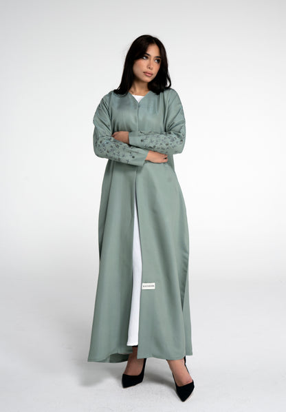 Girl wearing light green abaya with floral embroidered sleeves with bead embellishment