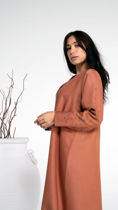 Side view of thread floral embroidered sleeve with bead embellishment on orange abaya.