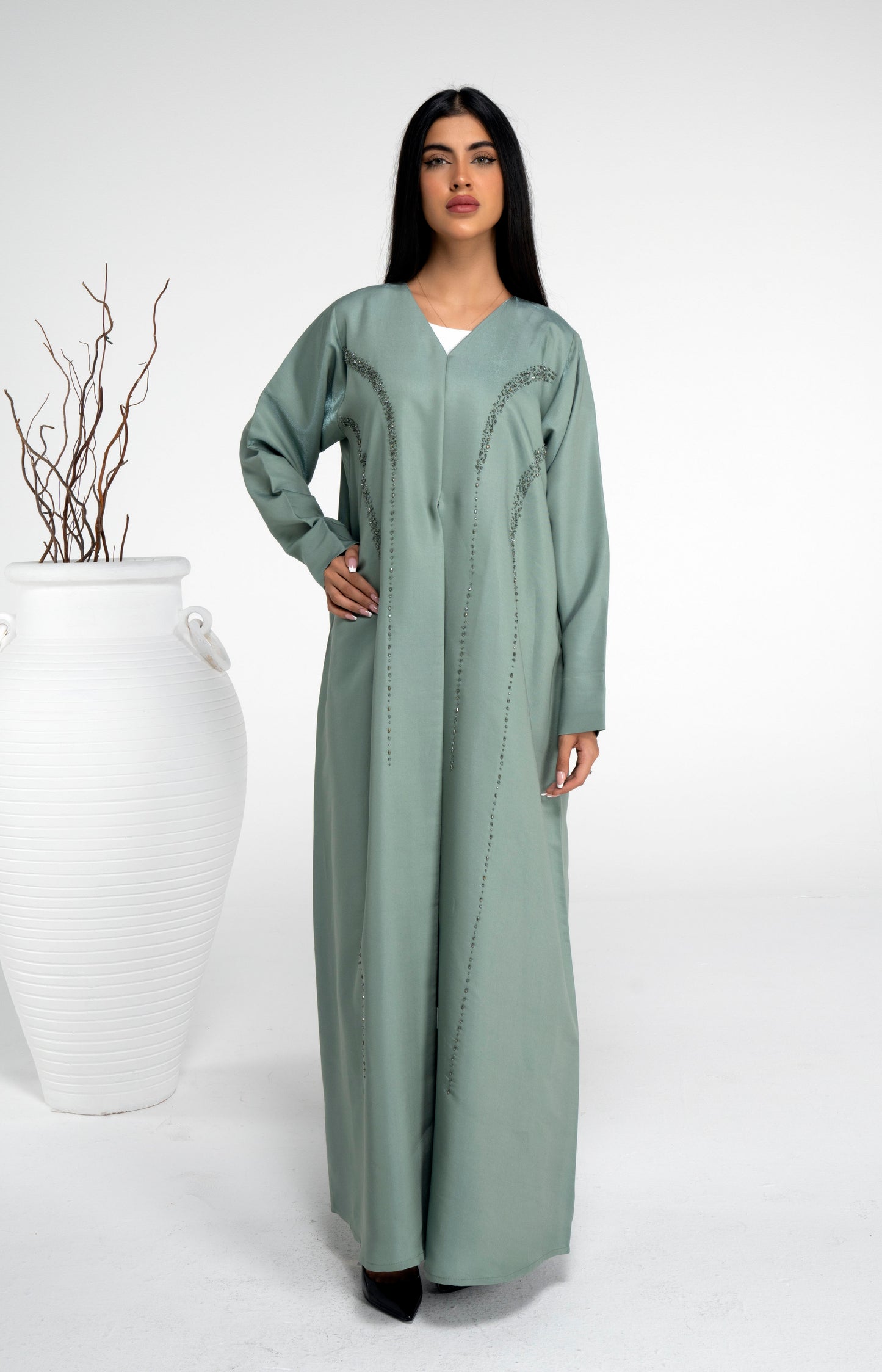 Girl wearing light green abaya with bead embellishments