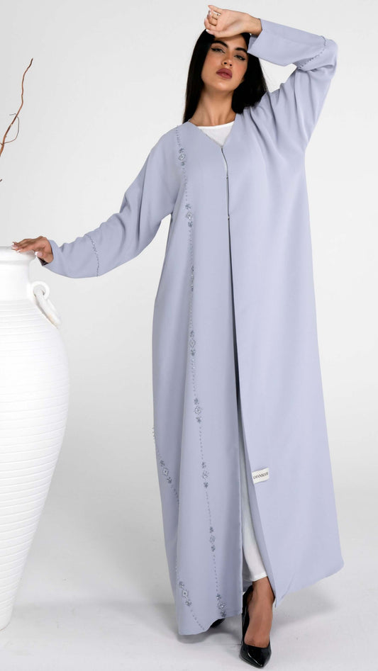 Girl wearing light grey abaya with flower motif design line on front and simple bead line on sleeve