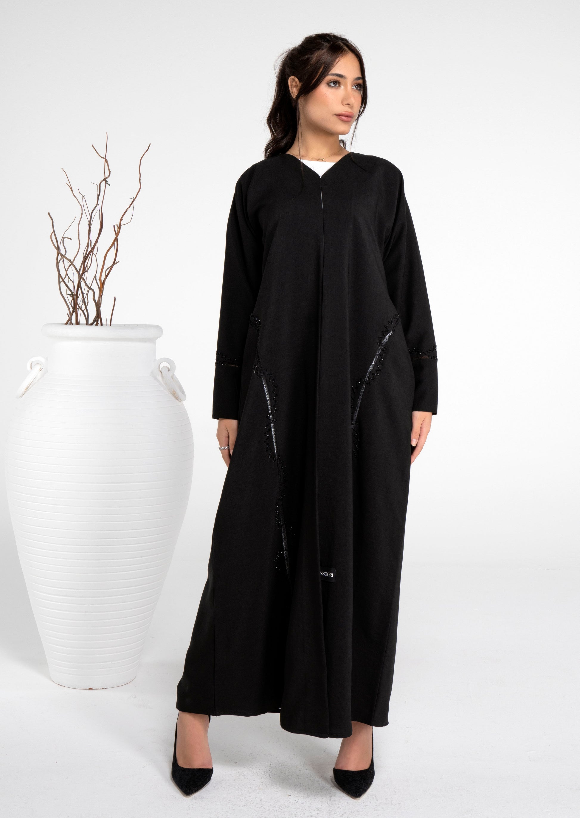 girl wearing black abaya with bead embellishments