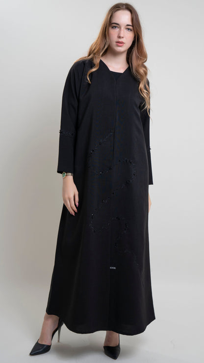 girl wearing black abaya with floral curve line embroidery and bead embellishments on front and sleeve