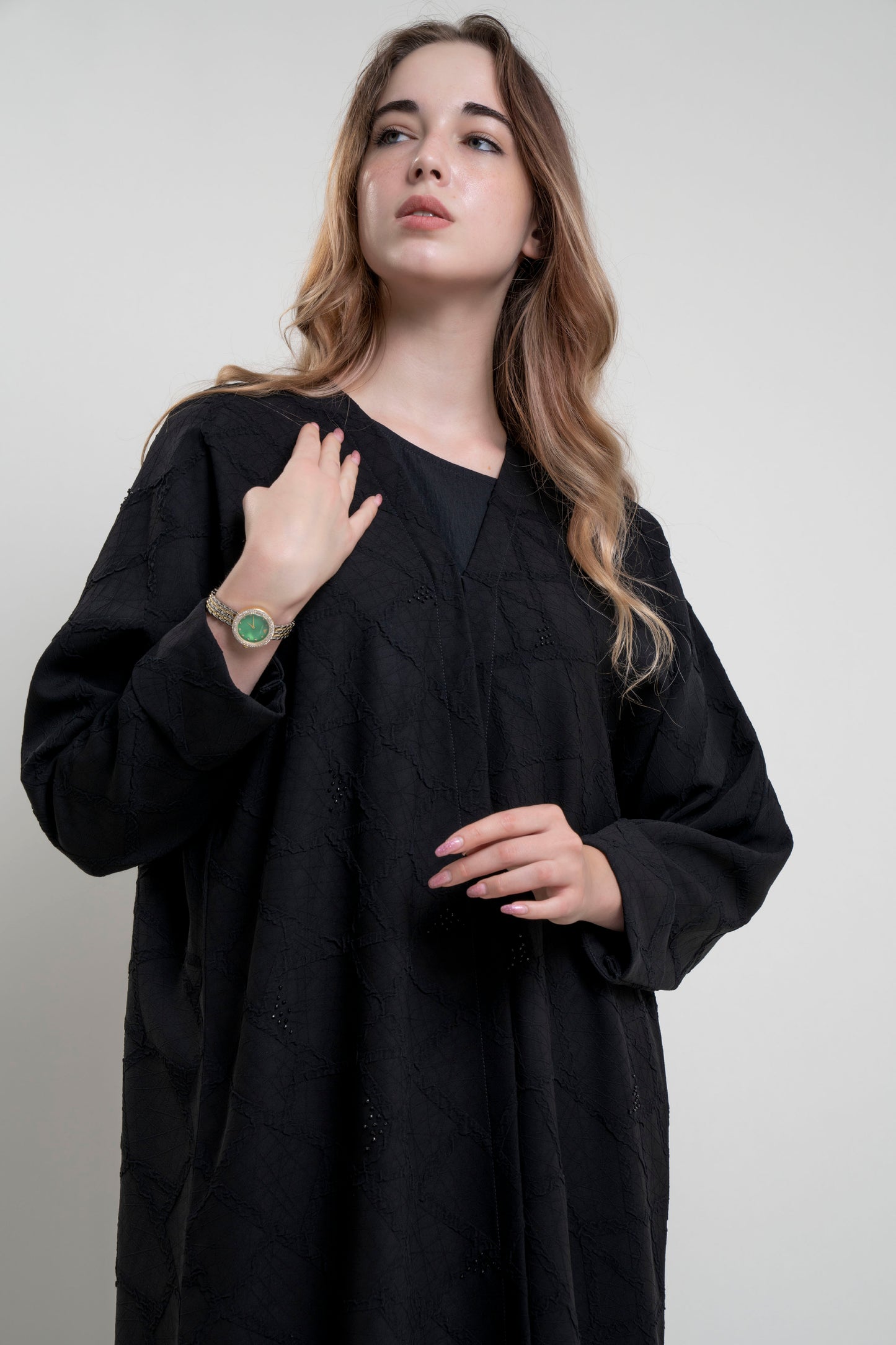 Half view of model wearing Bisht black Abaya with Simple Bead Highlights