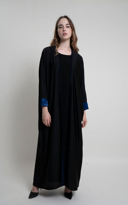 Full view of black bahrini style abaya with blue color cuff sleeve and piping on front line