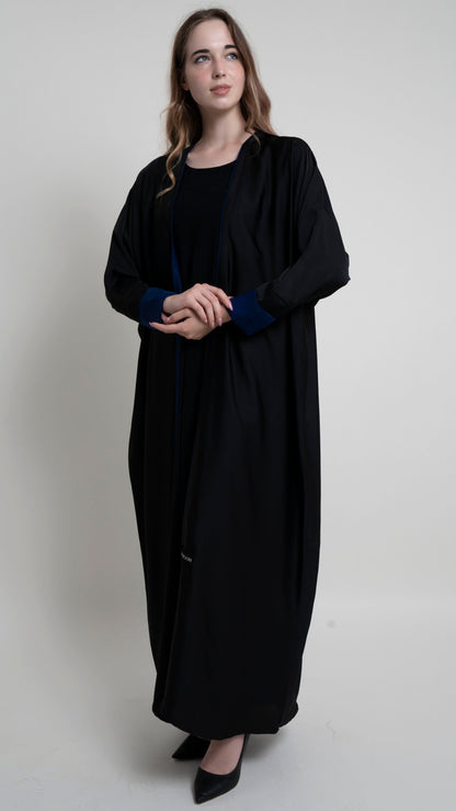 Girl wearing black bahrini style abaya with blue color cuff sleeve and piping on front line