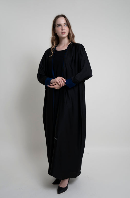 Girl wearing black bahrini style abaya with blue color cuff sleeve and piping on front line