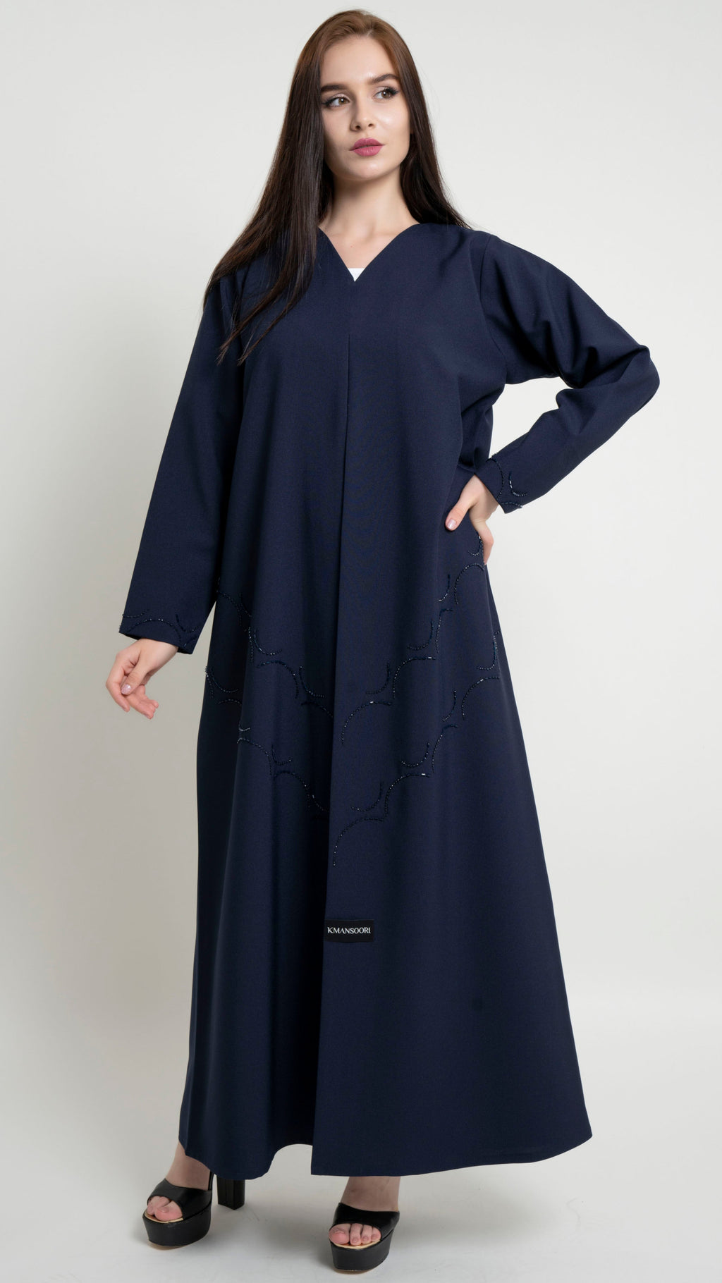 Girl with dark blue abaya with curved bead embellishment on front and sleeve 
