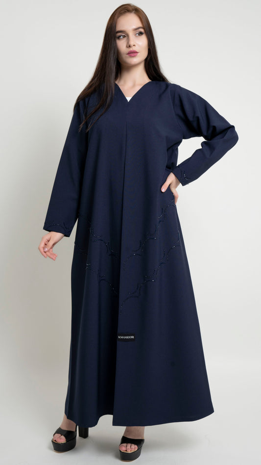 Girl with dark blue abaya with curved bead embellishment on front and sleeve 