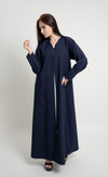 Girl wearing dark blue abaya with curved bead embellishment on front and sleeve 