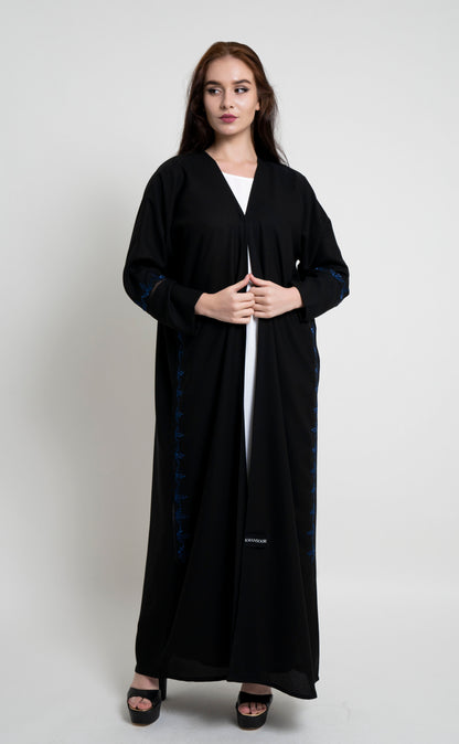 Girl wearing black abaya with floral design thread embroidery.
