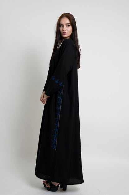Side view of black abaya with floral design thread embroidery on side and sleeve.