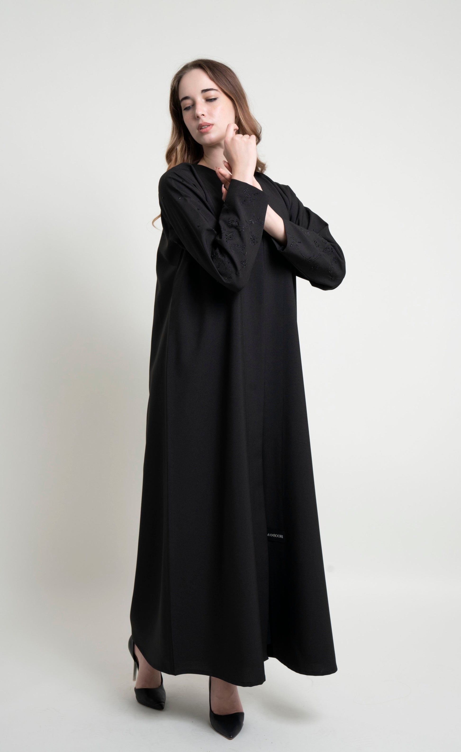 Girl wearing black abaya with embroidered sleeves 
