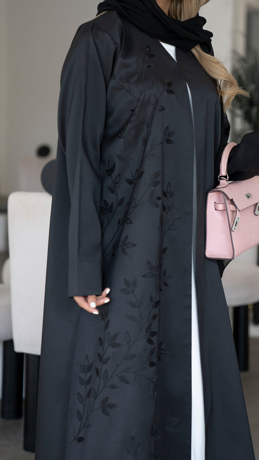 عباية من الساتان الأسود مع رقعة زهور مقطوعة بالليزر على الجهة الأمامية