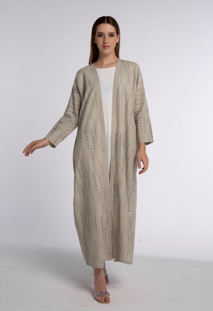 Girl wearing beige abaya with cut joined sleeve pattern.