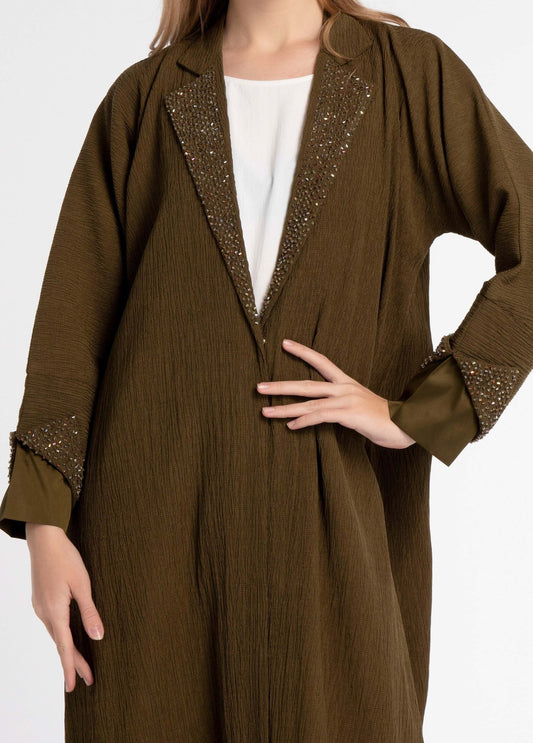 Detailed view of embellished design on green abaya