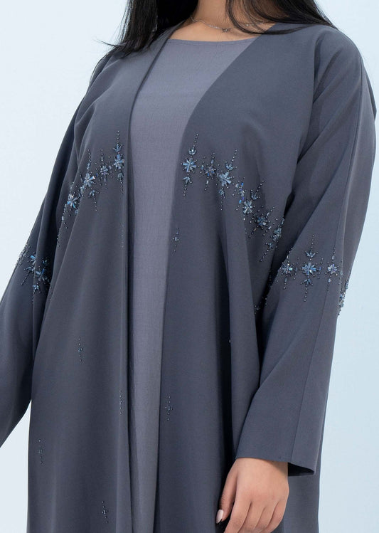 عباية بشت باللون الرمادي مع زخارف نجمية لامعة على الخط الأمامي تمتد حتى الأكمام