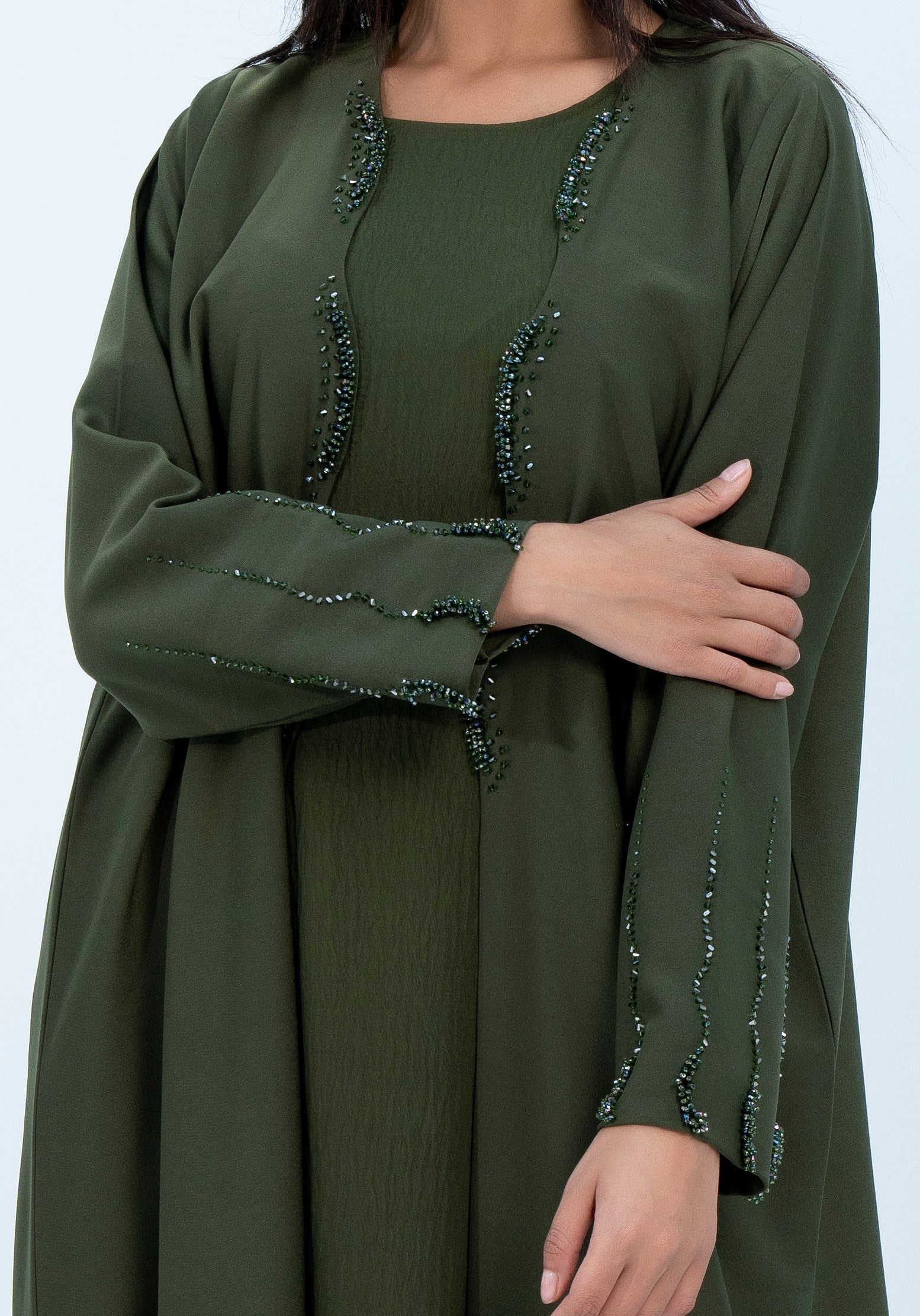 Detailed view of curved cut embellishments on flaps of abaya and sleeves