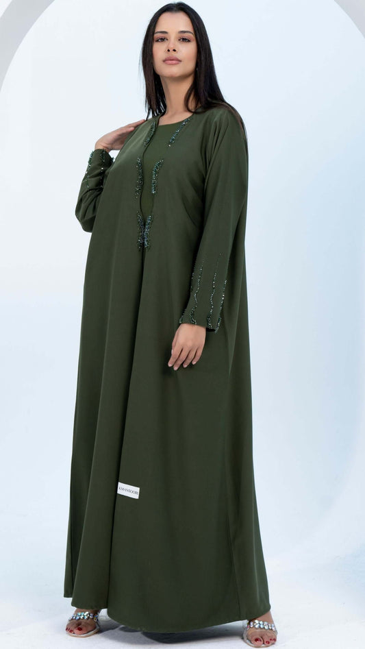Girl wearing green bisht abaya with curve cut embellishments