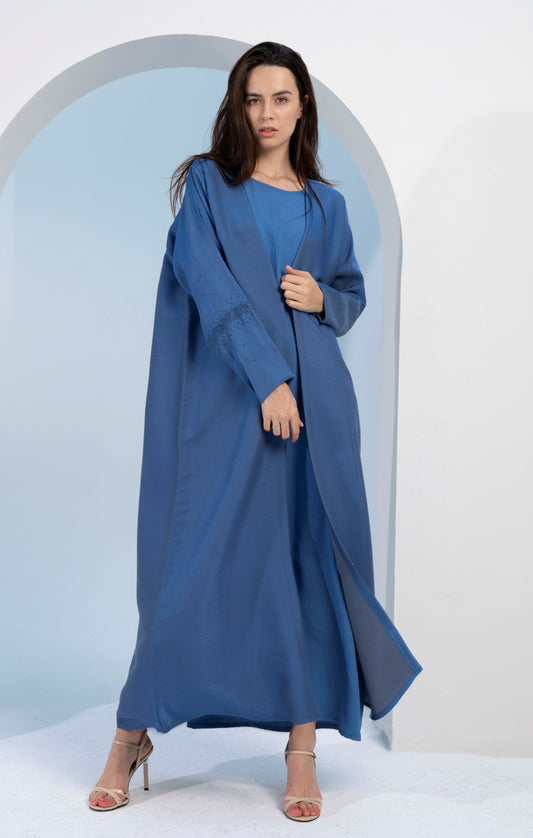 Girl wearing sky blue colored bisht abaya with sparkling embellishments.