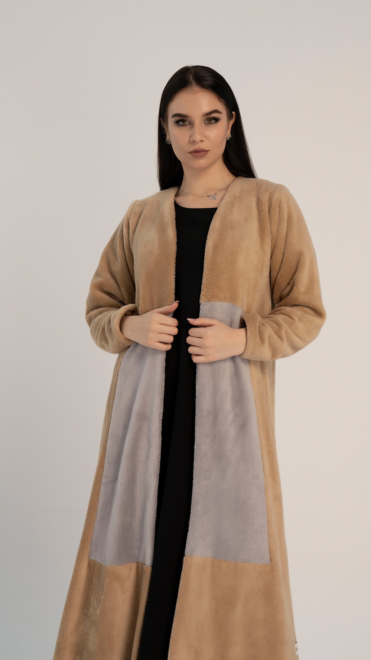 Girl wearing woolen abaya for women with color block pattern on front.